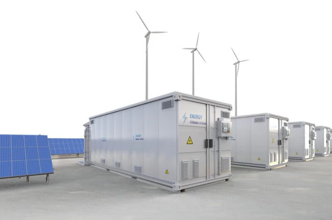 A line of energy storage units next to blue solar panels with three windmills in the background.