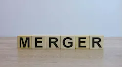 The word 'MERGER' spelled out on wooden blocks on a wooden surface