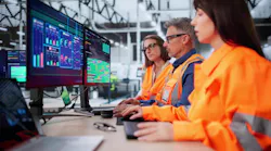 Technician In Modern Industrial Control Room Monitors SCADA For Automation.