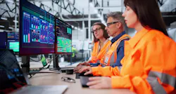 Technician In Modern Industrial Control Room Monitors SCADA For Automation.