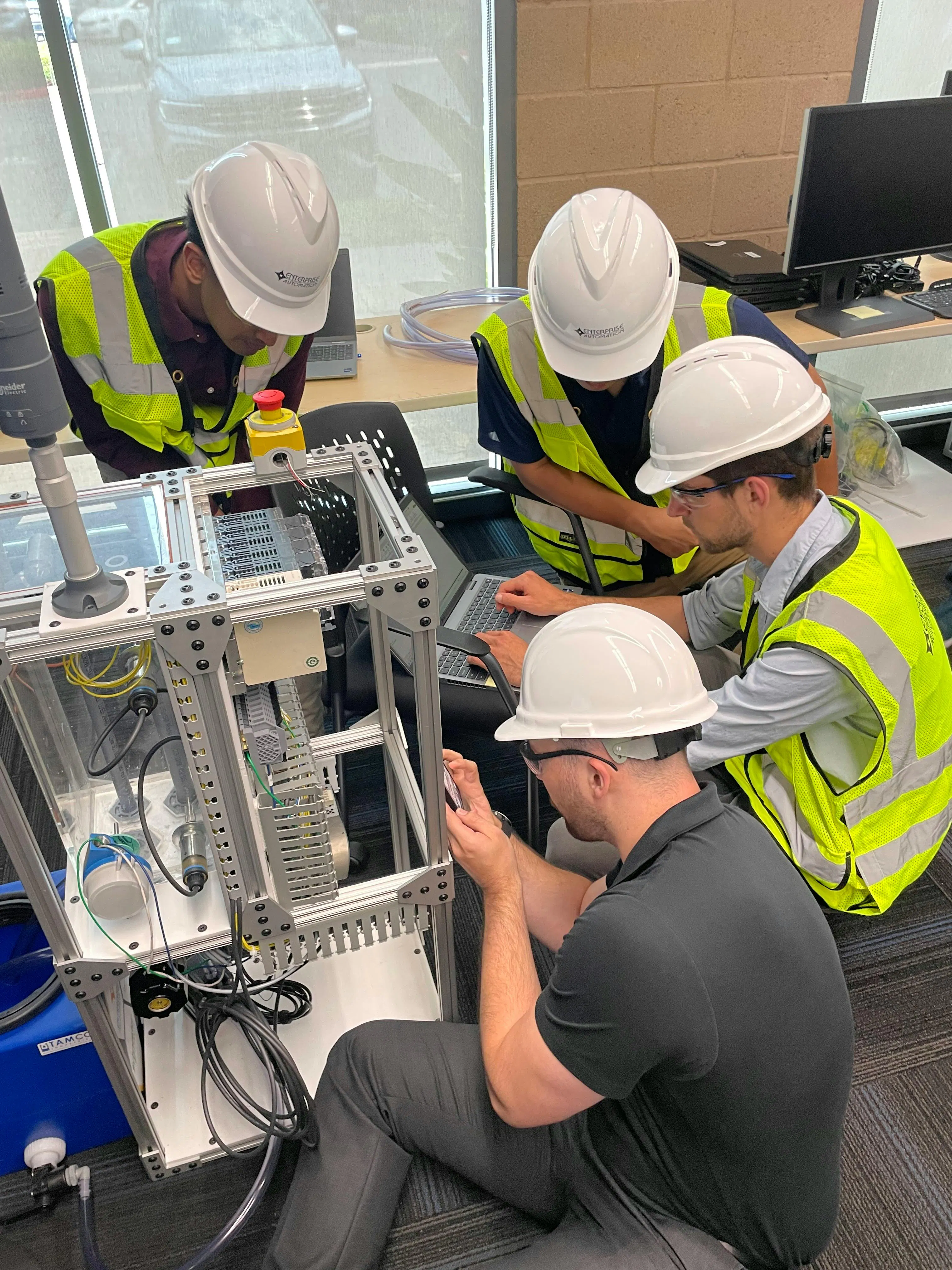 Figure 1: Using appropriate safety gear, participants in Enterprise Automation&rsquo;s homegrown EA University practice conducting a mock site investigation. They include (l. to r.) Joseph Pallan, controls engineer II, Cain Chen, controls engineer I, Atticus Binder, controls engineer I, and Alec Zerza, [ex]-controls engineer I.