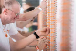 A team of Weidmüller employees, including Frank Polley, terminals business unit VP, wires 500 terminal blocks with a total of 1,000 connection points using Snap In connection technology in a verified 2 minutes 55 seconds to set an official Guiness World Record for fastest time to connect 500 terminal blocks into one chain by a team.