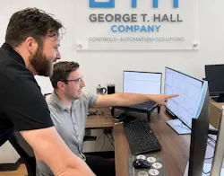 Dylan Lane, digital manufacturing systems manager (standing), and Gotzon Mugica, lead control systems engineer III (seated), review code for an upcoming project at George T. Hall, a system integrator in Anaheim, Calif.