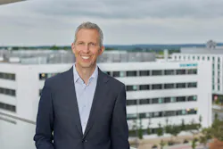 Rainer Brehm headshot in front of a skyline