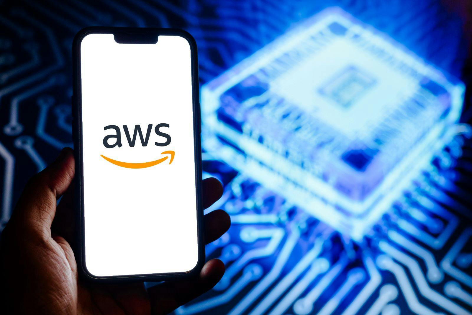 Amazon Web Services logo on a smartphone against the background a blue glowing AI chip
