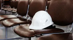 Construction helmet on an empty seat in a conference room.