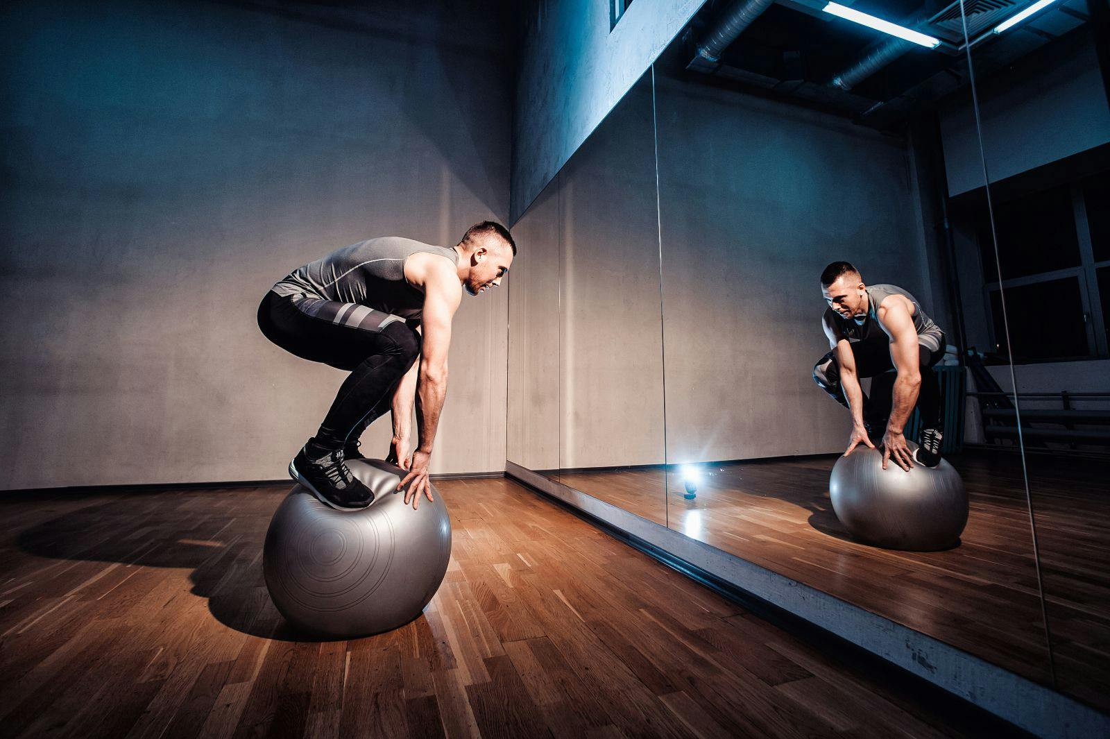 Fit man exercising with a ball for balancing workout.