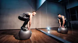 Fit man exercising with a ball for balancing workout.