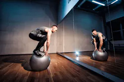 Fit man exercising with a ball for balancing workout.